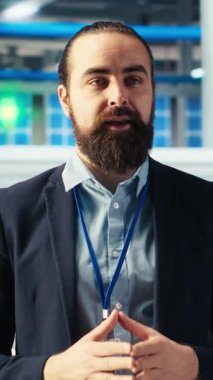 Güneş paneli fabrikasındaki dikey video adam konuşuyor, yenilenebilir enerji üretimi hakkında bilgilendirme videosu çekiyor. Photovoltaics fabrikası uzman kayıt videosu, güneş paneli üretimini açıklıyor