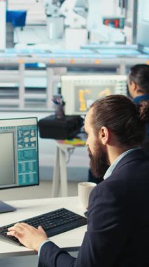 Fotovoltaik fabrikasındaki dikey video mühendisi arızalı sistemleri tanımlamak için gerekli belgeleri gözden geçiriyor. Güneş panelleri, dinlenme süresini azaltmak için fabrika işçisi inceleme verilerini okuyor.