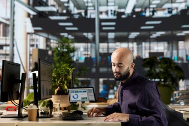 Orta Doğulu çalışanlar masa başında idari işleri denetliyor, başarı için organizasyonel performans ölçümlerini gözden geçiriyorlar. Stratejik planlamaya odaklı verileri analiz eden yetenekli bir yönetici.