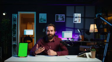 Stüdyoda teknoloji meraklıları için krom anahtar eleştirisi çeken mutlu bir konuşmacı. Neşeli medya yıldızı teknoloji internet şovuna ev sahipliği yapıyor, izole ekran dijital taşınabilir aygıtı, kamera B