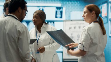 Profesyonel doktorlar iyi bir sağlık sigortası hizmeti için özel klinikteki hastane kayıtlarını ve tedavi planlarını gözden geçirirler. Çeşitli uzmanlar çözümler için test sonuçlarını analiz ediyorlar. Kamera A.