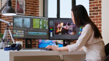 Freelancer Asyalı kadın video yapımcısı bir film projesinde çalışıyor, çift monitörlü çoklu görev, yazılım düzenleme ve çalışma alanında renk çarkı. Film kurgu endüstrisi. Kamera B.