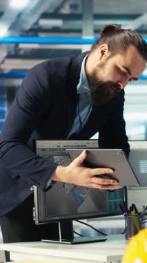 İşçilere yeni geliştirilen güneş enerjisi sistemi prototiplerinin nasıl kullanılacağını göstermek için tablet kullanan dikey video güneş paneli imalat uzmanı. Araştırmacı, çalışanların yeni fotovoltaik materyallerini sunar