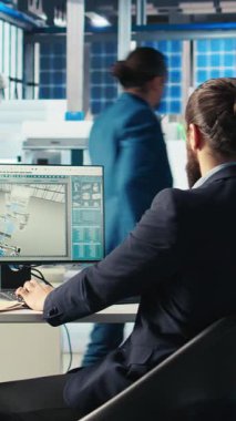 Dikey video Photovoltaics fabrika yöneticisi, üç boyutlu yazılım araçları ile güneş pilleri tasarımlarını görselleştirdikten sonra, bilgisayar katına göre tesis zeminini şekillendirmek için çalışma masalarına yürüyor