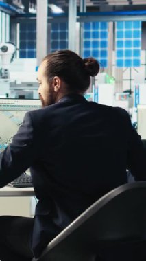 Fotovoltaik fabrikasındaki dikey video mühendisi arızalı sistemleri teşhis eden yeşil enerji güneş hücreleri üretiyor. Çevre dostu güneş panelleri fabrika teknisyeni üretiyor.