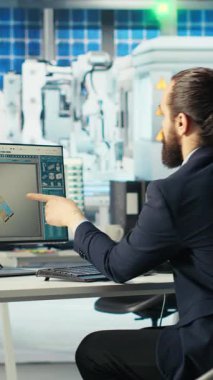Dikey video Photovoltaics fabrika müdürü güneş pilleri tasarımlarını 3D yazılım araçlarıyla görselleştiriyor, kahve içiyor. Güneş panelleri bitki teknisyeni CAD programında bilgisayar simülasyonları yapıyor.