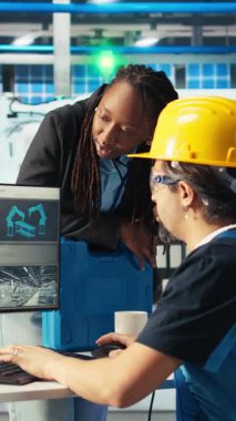 Dikey video Photovoltaics fabrika müdürü yenilenebilir enerji jeneratörlerinin uzman üretim modelleri tarafından yapılan çalışmaları denetliyor. Güneş panelleri güneş enerjisi üreten teknisyen denetleyicisi