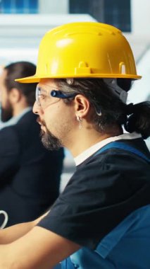 Dikey video Photovoltaics fabrika müdürü robot silah üreten güneş panellerinden yapılan mühendislik geliştirmelerini gösteriyor. İnsan, güneş santralini inceledikten sonra gerekli teknisyen güncellemelerini gösteriyor