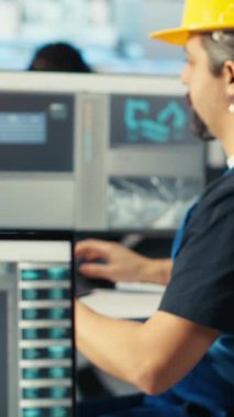 Dikey video Photovoltaics fabrika mühendisi CAD yazılımı kullanıyor, tesis katında planlama yapıyor. Güneş panelleri fabrika teknisyeni üretiyor. Bilgisayar, kamera B 'de montaj hatları dizayn ediyor.