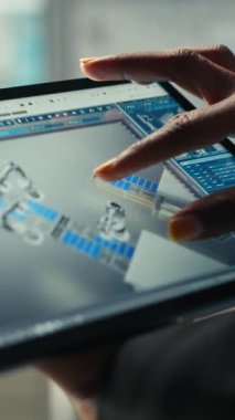 Dikey video Photovoltaics fabrikası uzmanı CAD uygulamasındaki üretim hatlarını tablet kullanarak dizayn ediyor. Güneş panelleri fabrika teknisyeni üretim planlarını optimize etmek için aygıt üzerinde simülasyon yazılımı kullanır