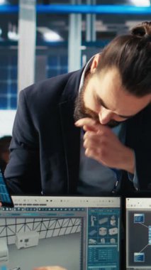 CAD yazılımında çalışan dikey video Photovoltaics fabrikası mühendisi müdürle beyin fırtınası yapıyor. Güneş panelleri üretim fabrikası teknisyeni montaj hatları tasarlıyor, danışman bilgilendirme, kamera B