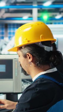 Dikey video Photovoltaics fabrika mühendisi CAD yazılımında tesis katında çalışmayı planlıyor, takım liderini gösteriyor. Güneş panelleri üretim fabrikası teknisyeni montaj hatları tasarlıyor, bilgilendirme