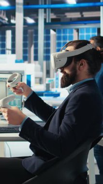 Dikey video Photovoltaics fabrika işçisi, robotların güneş panellerini montaj hatlarına yerleştirme performansını izlemek için VR kulaklık kullanıyor. Sanal gerçekliği kullanarak güneş santrali makinelerini denetleme uzmanı