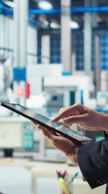 Fotovoltaik fabrikasındaki dikey video mühendisi arızalı sistemleri tespit etmek için tablet üzerindeki izleme yazılımını kullanıyor. Güneş panelleri fabrika işçisi üretimi durdurma süresini azaltmak için aygıt kullanır, kamera A