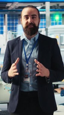 Güneş paneli fabrikasındaki dikey video adam konuşuyor, yenilenebilir enerji üretimi hakkında bilgilendirme videosu çekiyor. Photovoltaics fabrikası uzman kayıt videosu, güneş paneli üretimini açıklıyor