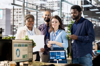 Çeşitli takım üyeleri, şirket hedeflerine, performans ölçümlerine ve organizasyonel büyüme için stratejik iş çözümlerine odaklanmak üzere işyerindeki bir masanın etrafında toplandılar..
