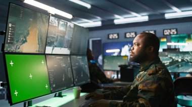 Hava kuvvetleri subayı komuta odasında taktik seviyesinde izleme yapıyor. Model ekran kullanarak. Saldırı bölgelerine ve kamera B 'ye bakmak için radarı kroma anahtar teçhizatında kullanan askeri uzman.