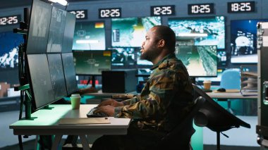 Hükümet tesisinde çalışan ordu uzmanı gözetleme teknisyeni, hedef verileri değerlendiriyor. Operasyon karargahında görev yapan bir asker, düşman kuvvetleri, kamera A ile çatışmaya girer.