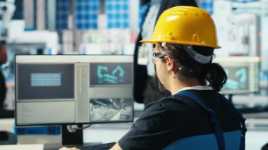 Fotovoltaik fabrikası uzmanı CAD 'ın bilgisayar programındaki tesis katında ayarlamalar yapmayı planlıyor. Güneş panelleri fabrika teknisyeni tasarım bantları, kamera B