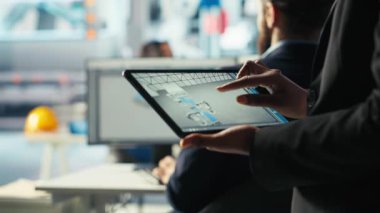 Güneş panelleri fabrikası çalışanı, yerleşim planlarını optimize etmek için tablet üzerinde CAD yazılımı kullanır. Fotovoltaik fabrika işçisi maksimum enerji çıkışı için düzenleme yapıyor Cihaz kullanarak, kamera B kapatın