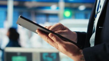 Fotovoltaik fabrikasındaki mühendis arızalı sistemleri tespit etmek için tablet üzerindeki izleme yazılımını kullanıyor. Güneş panelleri üreten fabrika işçisi, kapatma süresini azaltmak için aygıt kullanıyor.