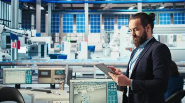 Fotovoltaik fabrikasındaki mühendisin portresi arızalı sistemleri teşhis etmek için tablet kullanıyor. Güneş panelleri fabrika işçisi üretimi durgunluğu azaltır ve operasyonel güvenilirliği korur, kamera A