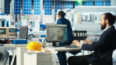 Fotovoltaik fabrika müdürü güneş pilleri tasarımlarını 3D yazılım araçları ile görselleştiriyor, kahve içiyor. Güneş panelleri bitki teknisyeni CAD programında bilgisayar simülasyonları yapıyor, içecekten keyif alıyor