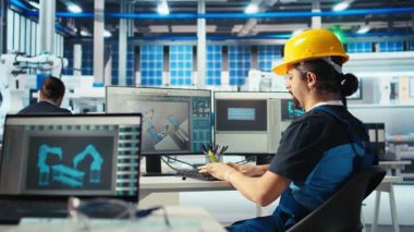 Güneş panelleri üreten fabrika teknisyeni, yerleşim planlarını optimize etmek için CAD programını kullanıyor. Fotovoltaik fabrikası çalışanı maksimum yenilenebilir enerji çıkışı için düzenleme yapıyor, kamera A