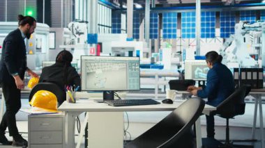 Fotovoltaik fabrika yöneticisi güneş mühendisliği ekibiyle çalışıyor, beyin fırtınası yapıyor, sistemlerin güvenilirliğini arttırıyor. İşçilere geri bildirim sağlayan güneş paneli üretim fabrikası uzmanı