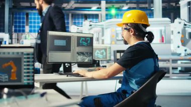 Fotovoltaik fabrikası uzmanı CAD 'ın bilgisayar programındaki tesis katında ayarlamalar yapmayı planlıyor. Güneş panelleri fabrika teknisyeni tasarım bantları, kamera A