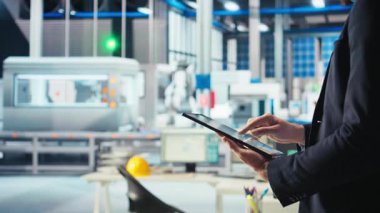 Fotovoltaik fabrikasındaki mühendis arızalı sistemleri tespit etmek için tablet üzerindeki izleme yazılımını kullanıyor. Güneş panelleri üreten fabrika işçisi, kapatma süresini azaltmak için aygıt kullanıyor. Kamera. Yakın çekim.