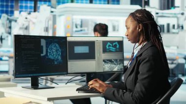 Fotovoltaik fabrikası programcısı yapay zeka kullanarak verileri analiz ediyor, sistem ölçümlerini gözden geçiriyor. Güneş panelleri, yapay zeka teknolojisi, kamera B kullanılarak teknik sorun giderme teknisyenleri