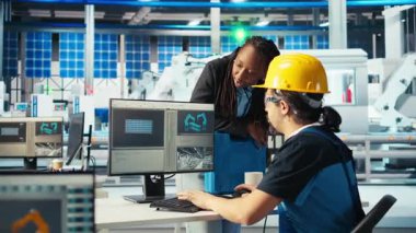 Fotovoltaik fabrikası yöneticisi yenilenebilir enerji jeneratörlerinin özel üretim modelleri tarafından yapılan çalışmaları denetliyor. Güneş panelleri, güneş pilleri inşa eden teknisyen ve kamera A 'yı denetleyen bitki denetleyicisi.