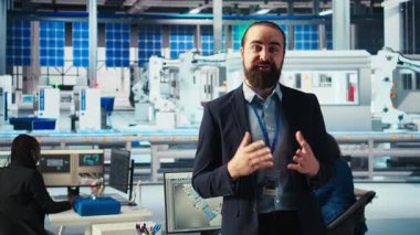 Güneş paneli fabrikası uzmanı, gelişmiş üretim ekipmanları ve yenilenebilir enerji çözümlerinin altını çizerek turneye çıkıyor. Endüstriyel tesislerdeki adam yeşil enerji üretim sürecini sunuyor, kamera A