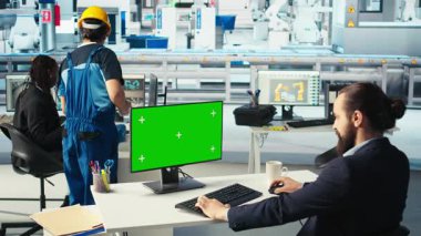 Photovoltaics fabrika işçisi yeşil ekrandaki sistem performansını izliyor. Güneş panelleri enerji üretimini ve verimliliğini izlemek için krom anahtar bilgisayar kullanan fabrika çalışanını üretiyor, kamera A