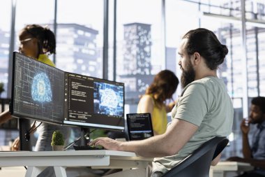 Kendi kendini öğrenme algoritmalarıyla insan beynini simüle eden yapay zeka hesaplaması için bilgisayar kullanan bir yönetici. Masaüstü bilgisayarında yapay zeka derin sinir ağlarıyla çalışan çalışanlar