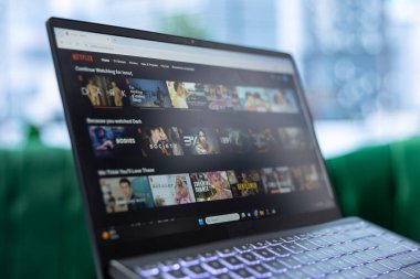 Bükreş, Romanya - 30 Temmuz 2024 - Genç CEO Netflix 'i modern ofisinde dinlenmek için kullanıyor, girişimci patron şirketteki zamanının tadını çıkarıyor. Lider, yayın hizmeti hakkında bir film arıyor.