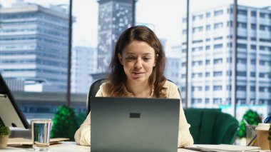 En sevdiği şarkılara imza atıp kariyer geliştirme hedefleri üzerinde çalışırken aynı anda birden fazla iş yapmasından memnundu. Üst düzey ofiste müzikle eğlenen genç bir kadın. Kamera A.