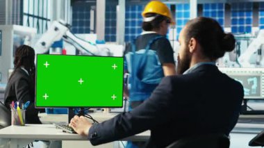 Fotovoltaik fabrikası mühendisi. Krom anahtar PC kullanarak güneş panelleri verimliliğini arttırıyor. Güneş panelleri, sürdürülebilir güneş çözümlerini model bilgisayar, kamera B kullanarak araştıran fabrika işçisi üretiyor.