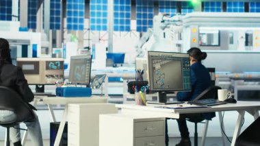 Fotovoltaik fabrikası mühendislerinden oluşan bir ekip sistem performansını izliyor. Güneş panelleri enerji üretimi ve verimliliğini izlemek için yazılım kullanan fabrika çalışanlarını üretiyor