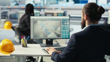 Fotovoltaik fabrikası işçisi kahve içiyor, robot kollarının performansını izliyor, güneş panellerini montaj hatlarına yerleştiriyor. İnsan bilgisayar masasında içecekten, güneş santrali makinelerinden, kamera B 'den hoşlanır.