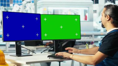 Photovoltaics fabrikası mühendisi izole ekran bilgisayarında enerji jeneratörlerinin modellerini yapıyor. Güneş panelleri çevresel olarak güvenli güneş pilleri inşa eden işçiyi bilgisayar görüntülerine yerleştirir, kamera B