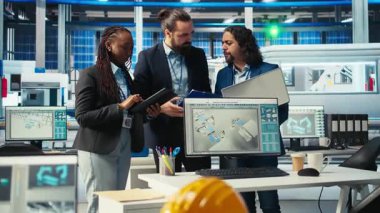 Fotovoltaik fabrikasındaki neşeli mühendisler arızalı sistemleri teşhis ettikten sonra beşlik çakıyorlar. Güneş panelleri üreten fabrika işçileri, durgunluğun azalmasını başarıyla kutluyor, kamera A