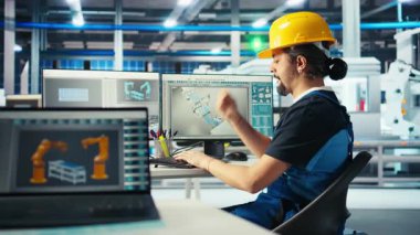 Fotovoltaik fabrikası mühendisi CAD uygulamasındaki tesisin zemininde sabit şapka takıyor. Çevre dostu güneş panelleri fabrika teknisyeni PC, kamera A 'da üretim hatları tasarlıyor.