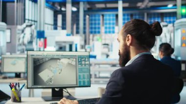 Fotovoltaik fabrikasındaki mühendis PC 'de kahve içiyor ve çalışan sistemleri teşhis ediyor. Güneş panellerinde içecekten hoşlanan bir adam fabrika üretiyor, dinlenme süresini azaltıyor, kamera A
