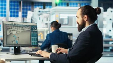 PC ekranındaki verileri analiz eden Photovoltaics fabrikası mühendisi, sistem sağlık ölçümlerini gözden geçiriyor. Güneş panelleri bilgisayar masasına sorun çıkaran çalışanlar yerleştirir, hata tanılama, kamera B