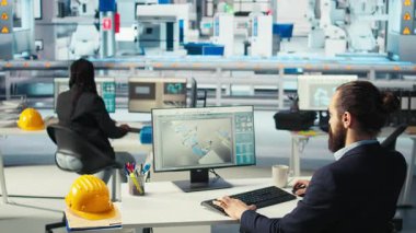 Fotovoltaik fabrikası işçisi kahve içiyor, robot kollarının performansını izliyor, güneş panellerini montaj hatlarına yerleştiriyor. İnsan bilgisayar masasında içecekten, güneş santrali makinelerinden ve kamera A 'dan hoşlanır.