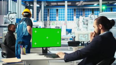 Fotovoltaik fabrikasında çalışan bir mühendis. Arızalı sistemleri teşhis etmek için krom anahtar bilgisayar kullanıyor. Güneş panelleri, yeşil ekran PC, kamera A kullanarak çalışma süresini azaltan fabrika işçisi üretiyor.