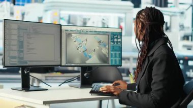 Fotovoltaik fabrikasında çalışan programcı, PC programını arızalı sistemleri teşhis etmek için kullanıyor. Kadın güneş panellerindeki bilgisayar masasında kodlama yapıyor fabrika üretiyor, çalışma süresini azaltıyor, kamera B