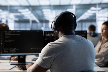 Bilgisayar ağı güvenlik veri merkezinde çalışan sistem yöneticisi, müzikten hoşlanıyor. Kulaklık takan çalışanlar sunucuları izliyor, enerji tüketimini arttırıyor, müzik dinliyor